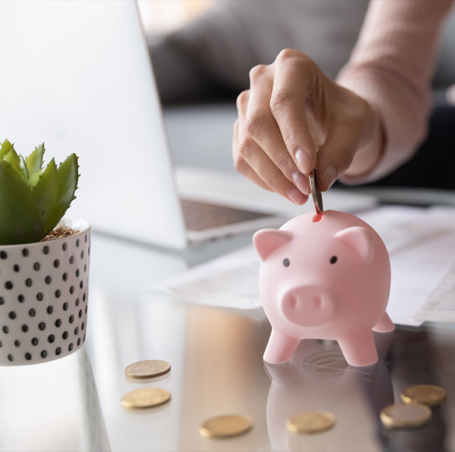 Image showing a close up of a woman's hand putting a penny in a piggy bank